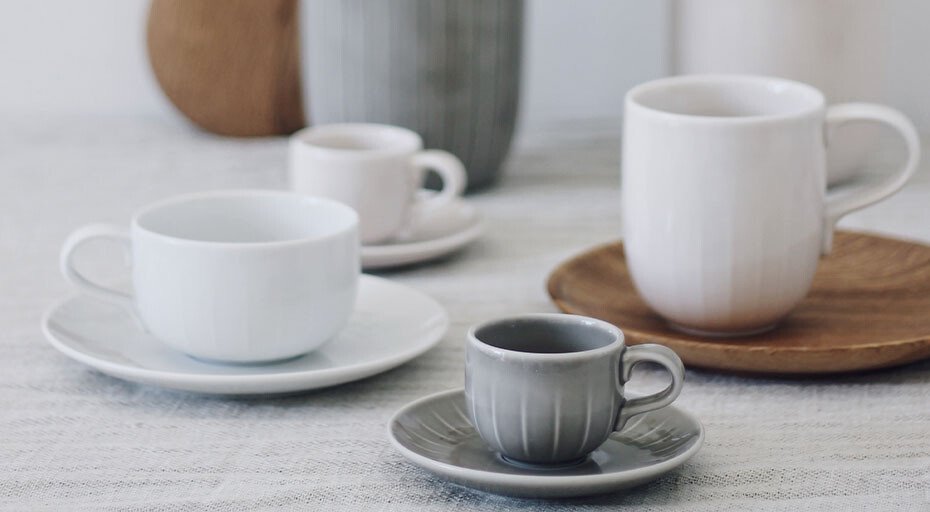 Verschiedene Tassen der Serie Joyn von Arzberg in unterschiedlicher Größe und Farbe auf einem Tisch arrangiert.