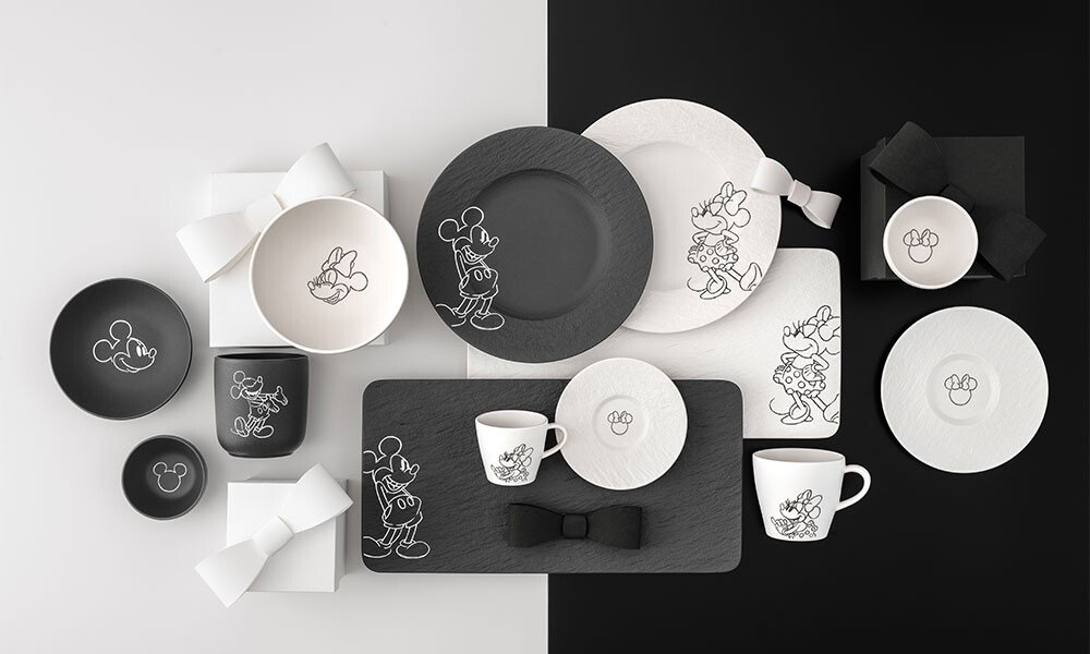 Geschirrset Villeroy &amp; Boch Manufacture Rock – Mickey Mouse in Schwarz-Weiß mit Mickey Mouse-Motiven, bestehend aus Tellern, Tassen und Schalen auf geteiltem Hintergrund.