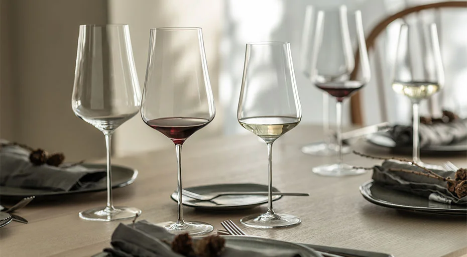 Mehrere Weingläser der Serie Duo von Zwiesel Glas auf gedecktem Tisch mit grauen Servietten.