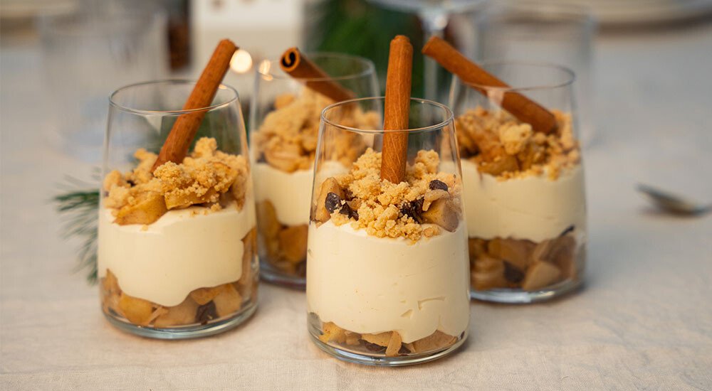 Vier Dessertgläser auf einem Tisch mit einer Süßspeise gefüllt.