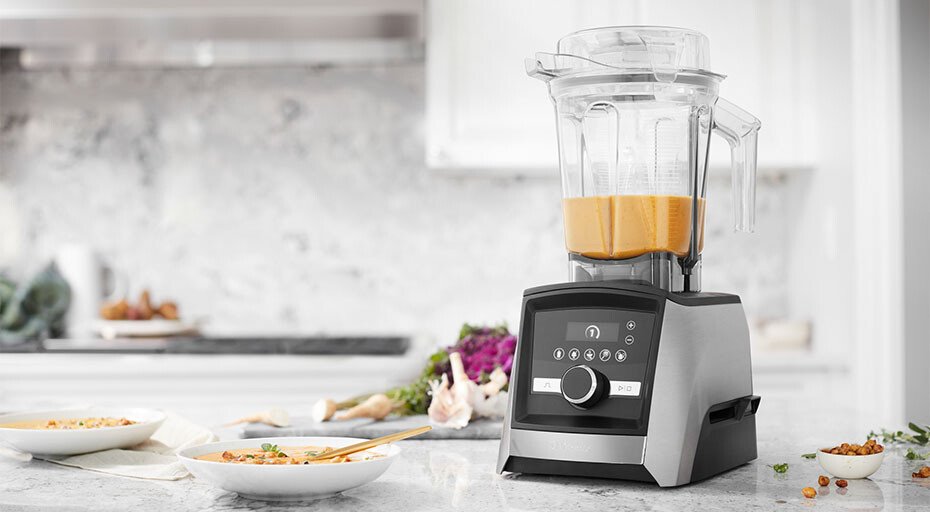 Ein moderner Standmixer von Vitamix auf einer Küchenarbeitsplatte, gefüllt mit einer orangenen Flüssigkeit.