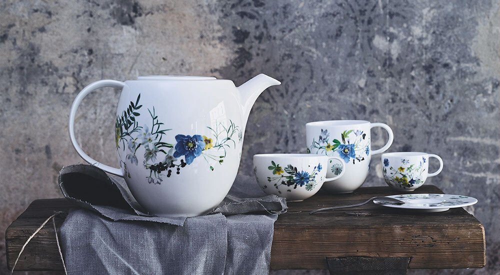 Geschirrteile der Serie Rosenthal Brillance Fleurs des Alpes drapiert auf einem Tisch