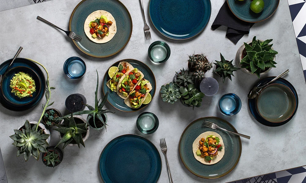 Herbstlich gedeckter Tisch mit blauen Villeroy &amp; Boch Tellern, Tacos, Limetten, Gläsern und Sukkulenten.