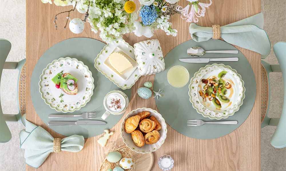 Festlich gedeckter Oster-Tisch mit zwei Gedecken der Serie Easter Delight von Villeroy &amp; Boch, Osterdekoration, Gebäck und Blumenarrangement, pastellfarben.