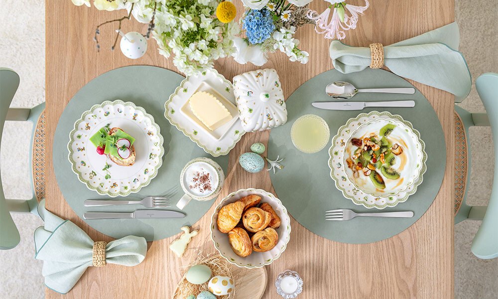 Festlich gedeckter Oster-Tisch mit zwei Gedecken der Serie Easter Delight von Villeroy &amp; Boch, Osterdekoration, Gebäck und Blumenarrangement, pastellfarben.