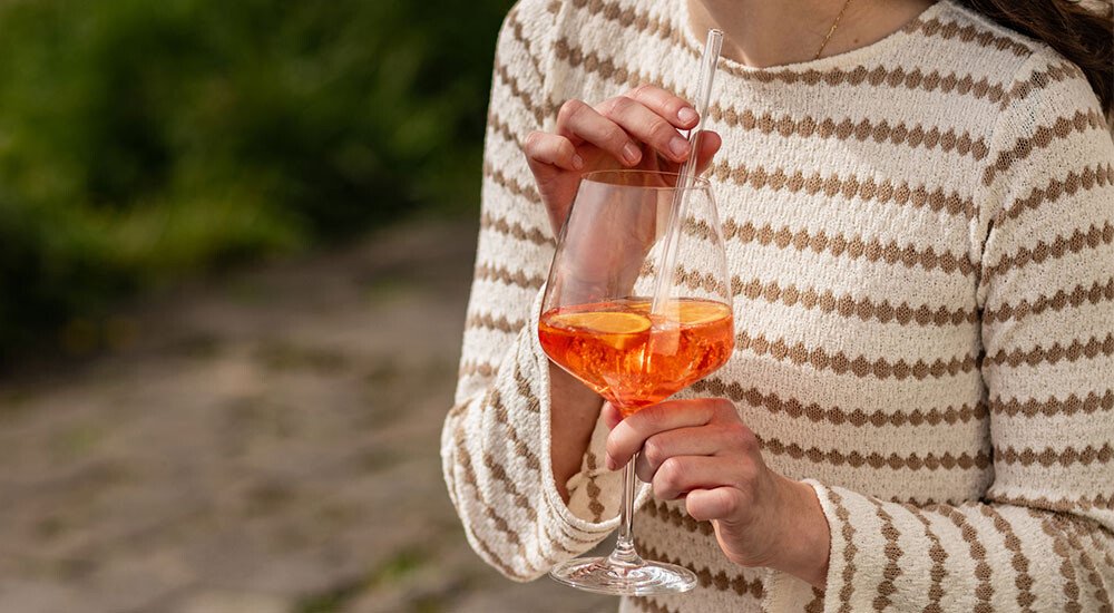 Eine Frau hält eine Aperol Glas.