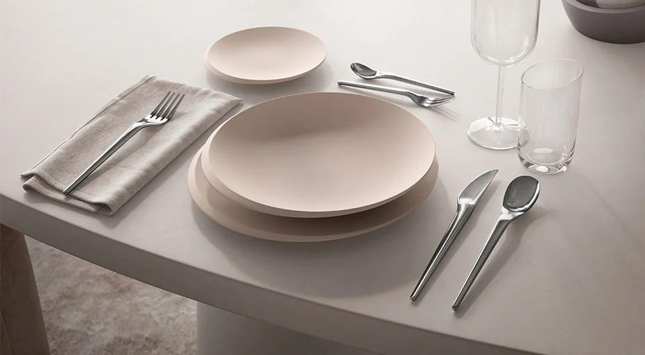 Elegantes Gedeck von Villeroy &amp; Boch mit Tellern, Besteck, Gläsern und Serviette auf einem hellen Tisch.