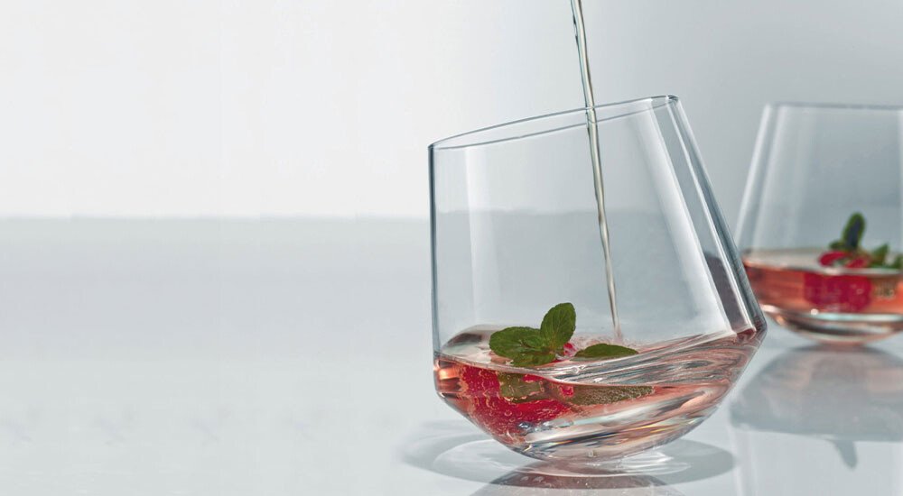 Ein Tumbler-Glas mit einem Getränk und einer Erdbeere