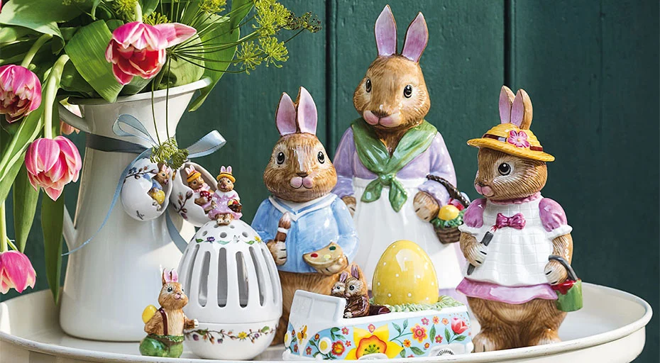Keramikhäschen und Ostereier der Serie Bunny Tales von Villeroy &amp; Boch auf Tisch, umgeben von Tulpen in Vase, dekoriert für Frühlingszeit in pastellfarbenem Ambiente.