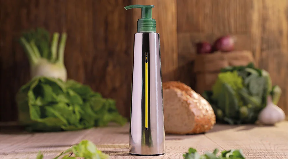 Ölflasche von Olipac auf Holzuntergrund, umgeben von Gemüse, Brokkoli, Zwiebeln und Brot im Hintergrund.