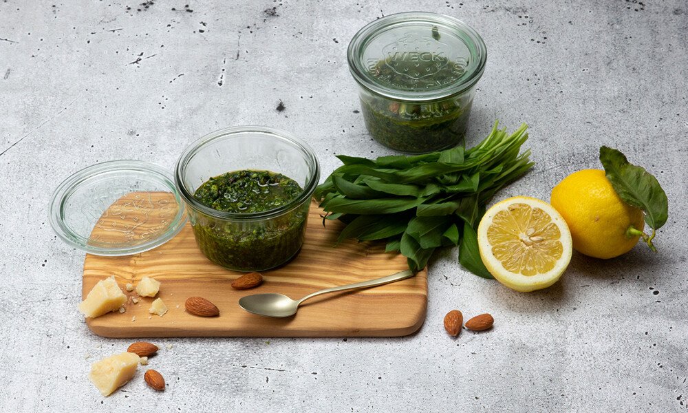 Bärlauchpesto auf einem Holzbrett und Zitrone