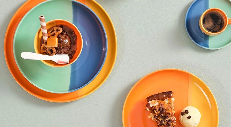 Buntes Geschirr der Serie Joy von ASA mit Dessert und Espresso; Teller und Tassen in Blau, Grün und Orange.