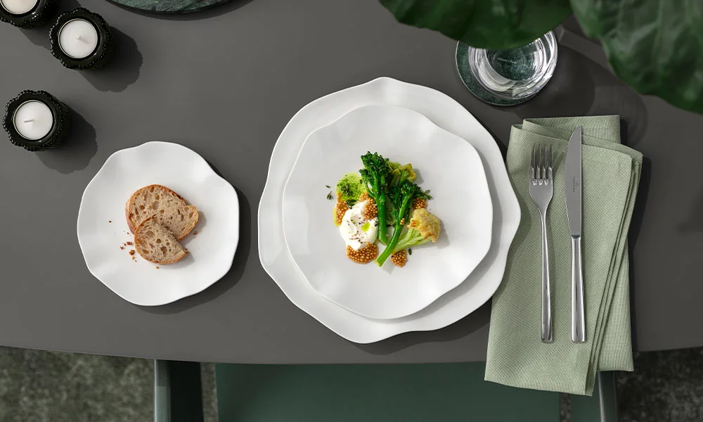 Elegantes Tischarrangement mit Gourmetgericht aus Brokkoli, Eier und Kaviar, serviert auf weißem Porzellangeschirr der Serie Pura von Villeroy &amp; Boch.